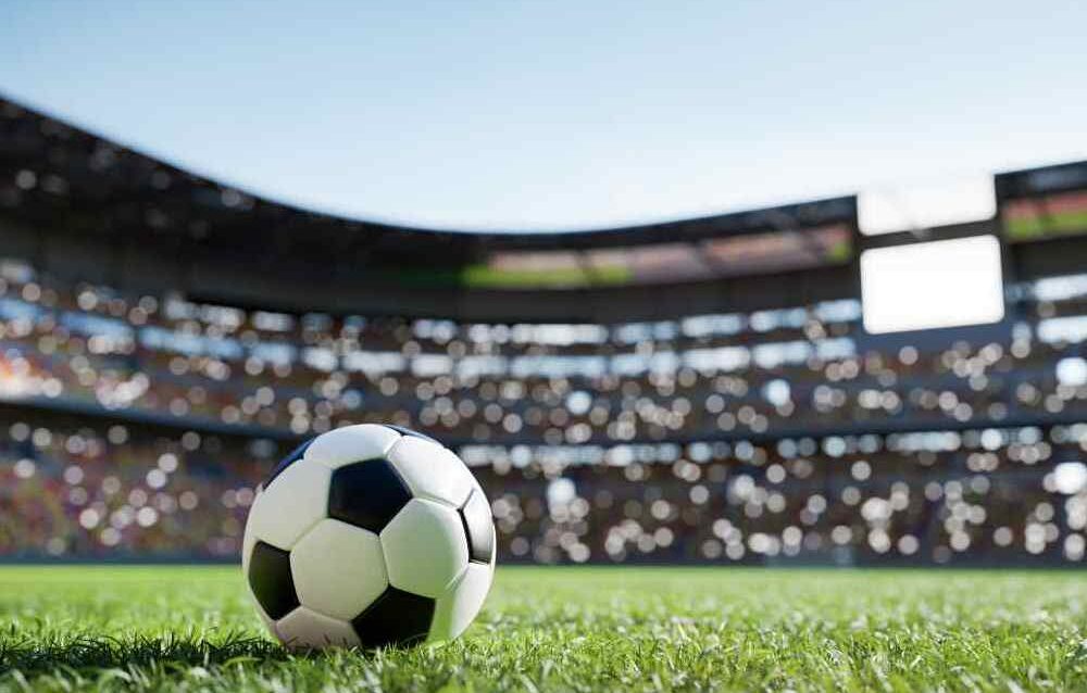 Football soccer ball on grass field on stadium
