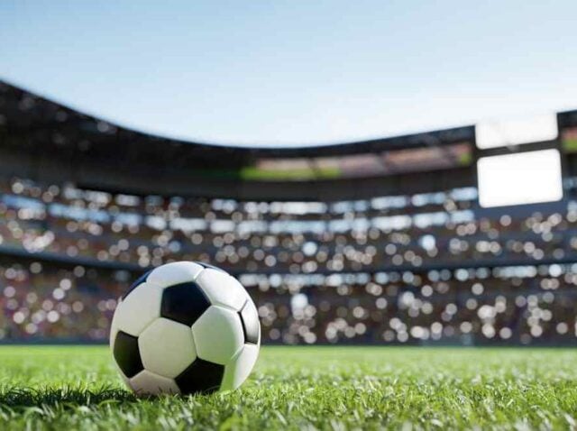 Football soccer ball on grass field on stadium